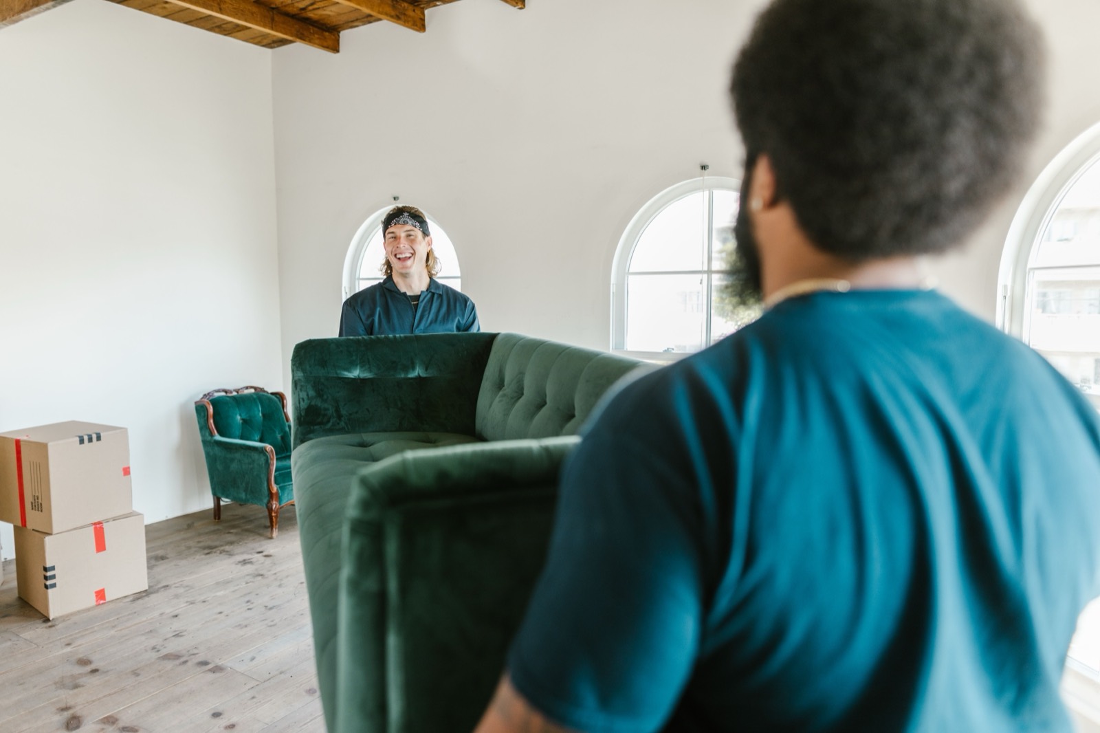 Two movers carrying a sofa together — stock photo, replace with a real photo of your van/team