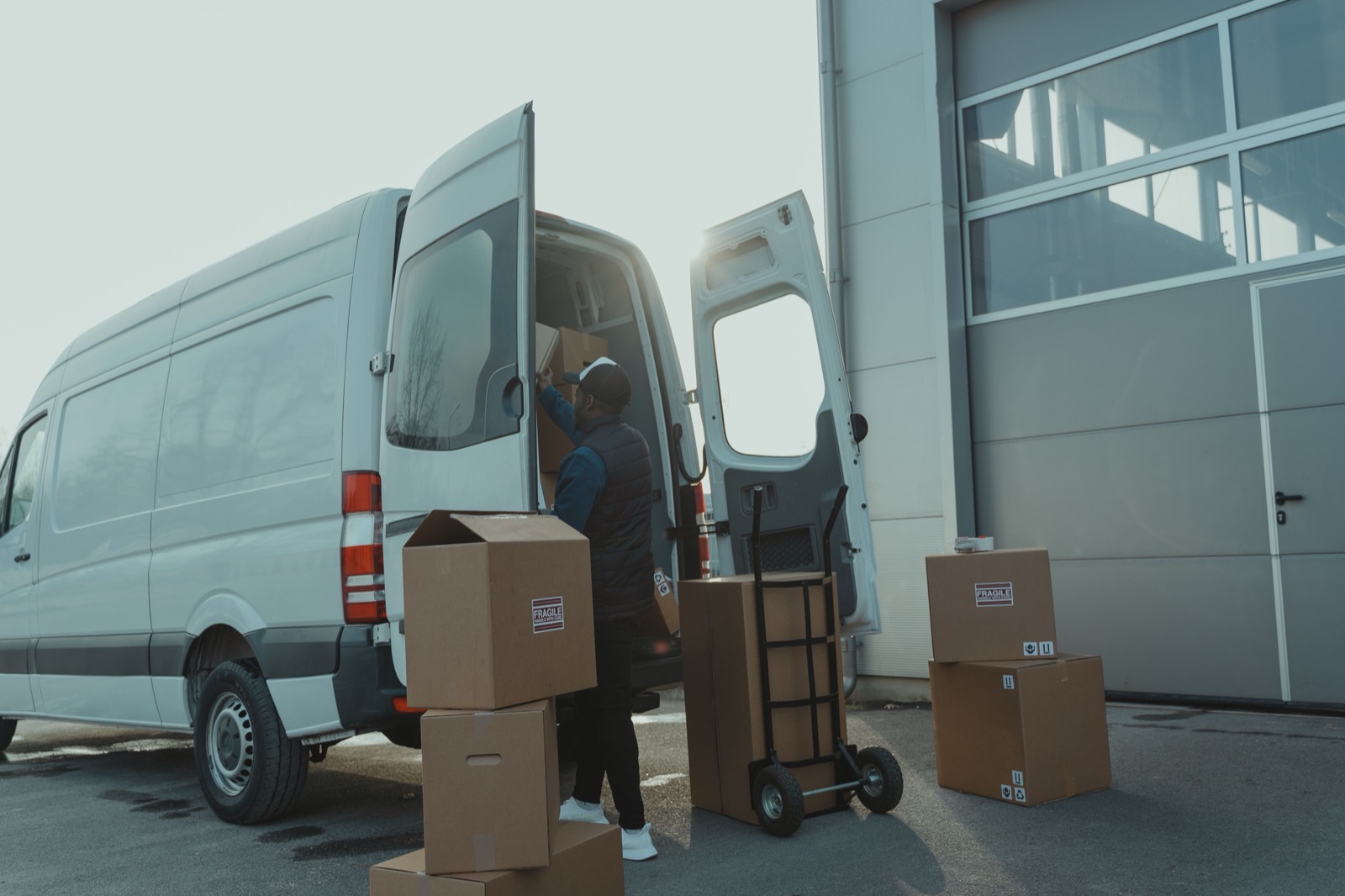 Removalist loading boxes into a van — stock photo, swap for a real photo of your van/team